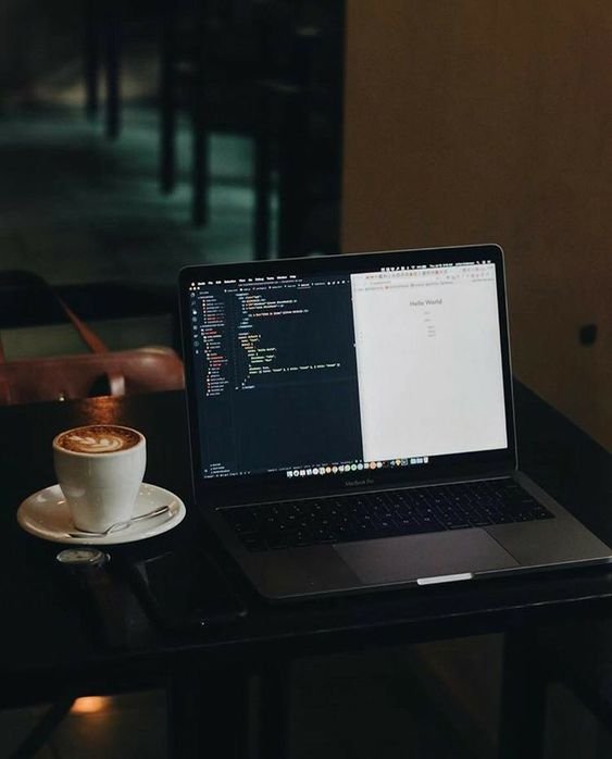 . Laptop and coffee on table, perfect setup for flutter development.