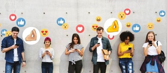 A group of individuals standing in front of a wall adorned with social media icons.
