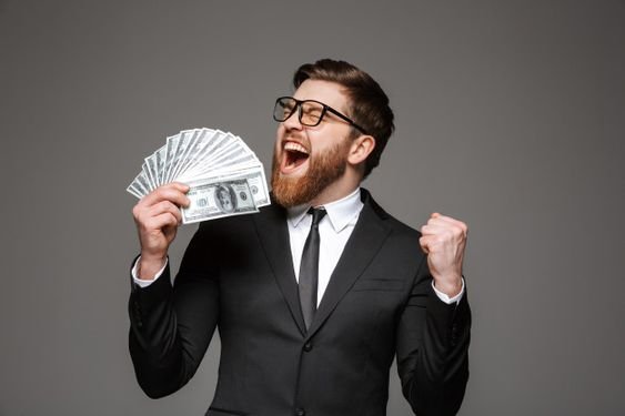  A businessman in a suit and tie holding a stack of money.
